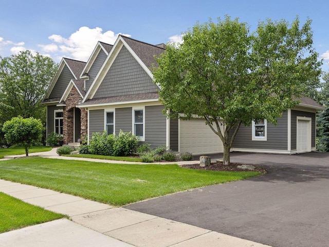 view of front facade with stone siding, a front yard, and roof with shingles