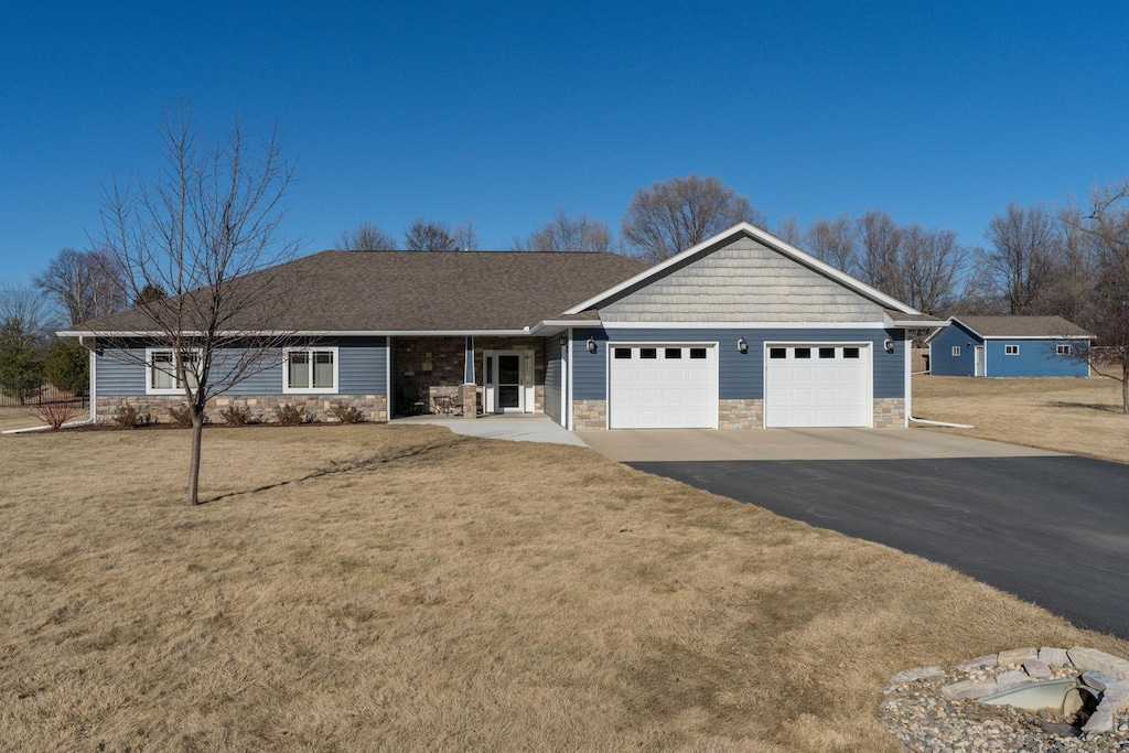 ranch-style house featuring a garage and a front yard