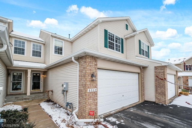 view of front of house featuring an attached garage and brick siding