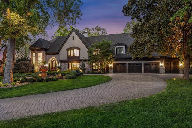 french provincial home with a garage and a yard