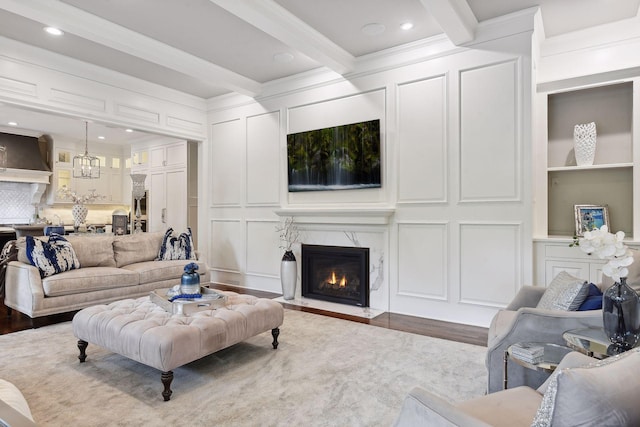 living room with beam ceiling, wood-type flooring, ornamental molding, and a premium fireplace