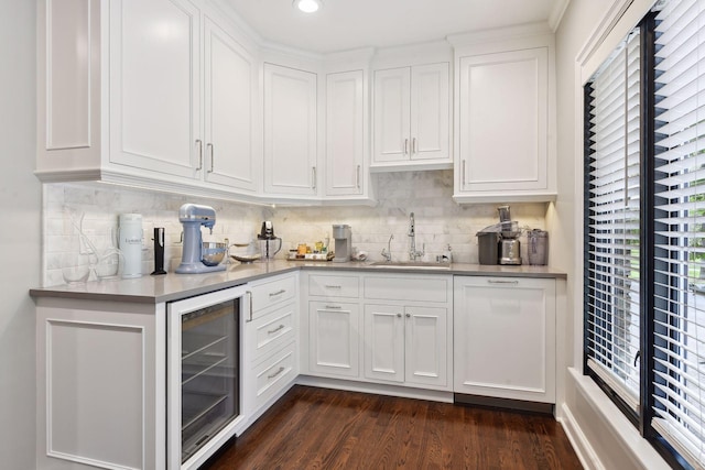 kitchen with wine cooler, sink, dark hardwood / wood-style floors, decorative backsplash, and white cabinets