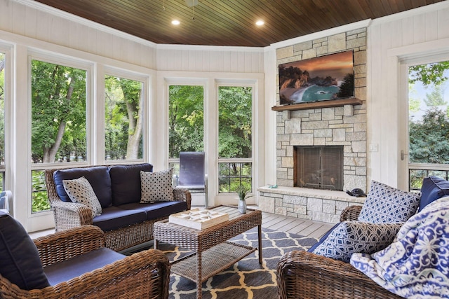 sunroom / solarium featuring wood ceiling and a stone fireplace