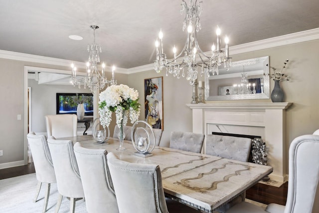 dining space with wood-type flooring, ornamental molding, an inviting chandelier, and a high end fireplace