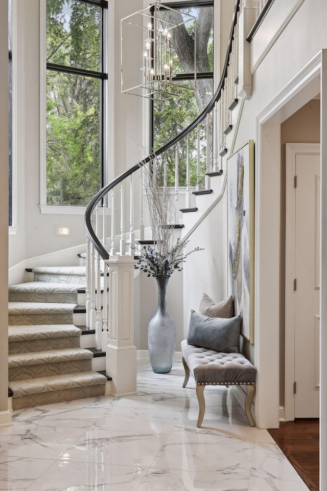 stairs featuring a chandelier