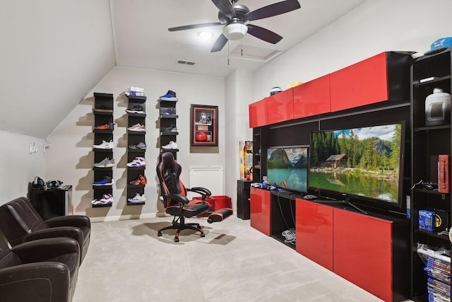 carpeted office space featuring vaulted ceiling and ceiling fan