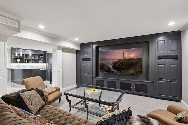 carpeted home theater room with bar and crown molding