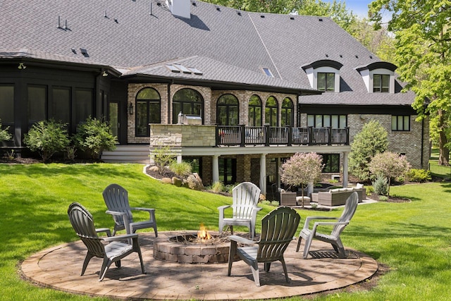 rear view of property with an outdoor fire pit, a patio, and a lawn