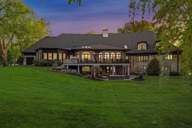 back house at dusk with an outdoor hangout area and a lawn