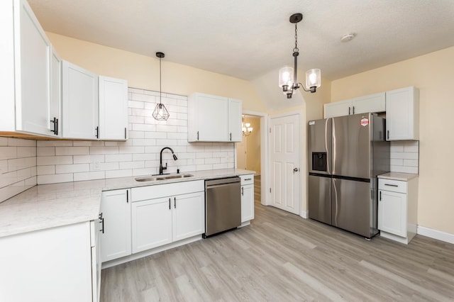 kitchen with white cabinetry, sink, decorative light fixtures, and stainless steel appliances