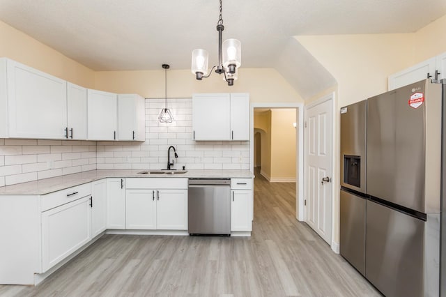 kitchen with stainless steel appliances, white cabinetry, hanging light fixtures, and sink