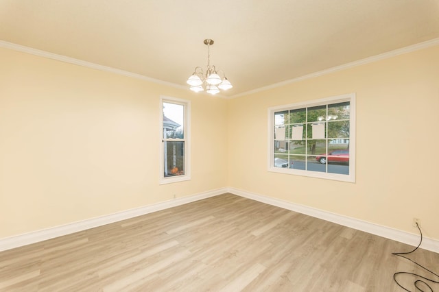 spare room featuring ornamental molding, a chandelier, and light hardwood / wood-style floors