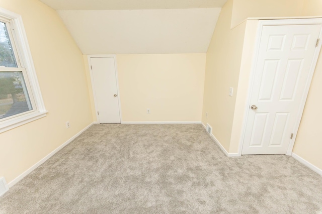 spare room with lofted ceiling and light carpet