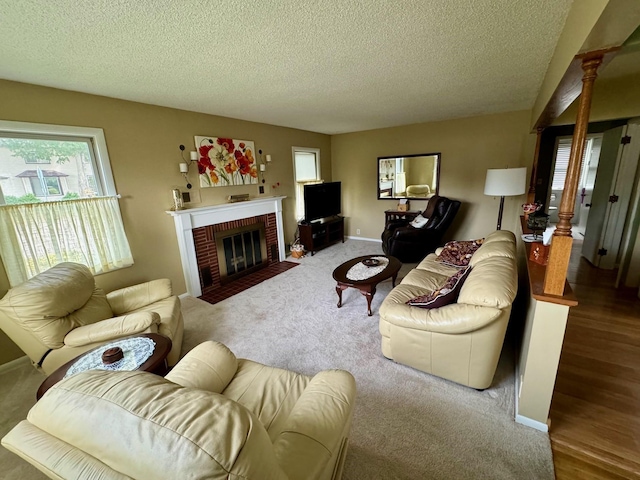 living room featuring a fireplace, carpet floors, and a textured ceiling