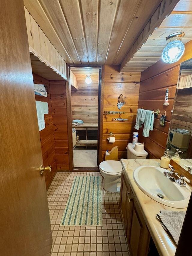 bathroom with vanity, wood walls, wood ceiling, and toilet