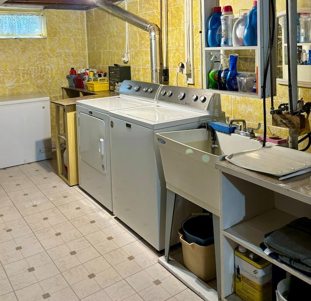 laundry area with washing machine and dryer and tile walls