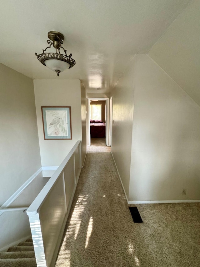 corridor with lofted ceiling and carpet flooring