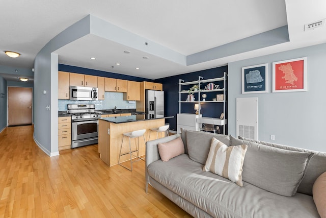 kitchen with stainless steel appliances, dark countertops, open floor plan, and visible vents