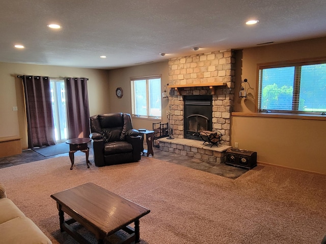 living room featuring carpet floors, a large fireplace, and a textured ceiling