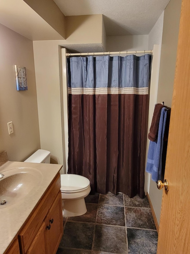 bathroom featuring vanity, a textured ceiling, curtained shower, and toilet