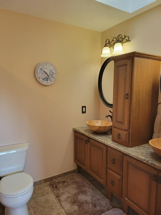 bathroom featuring vanity, toilet, and tile patterned flooring