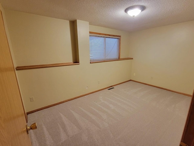 empty room featuring a textured ceiling and carpet flooring