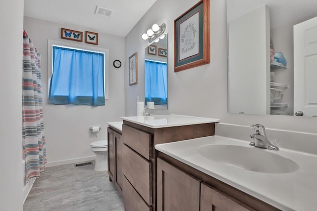 bathroom with a shower with curtain, vanity, toilet, and a textured ceiling