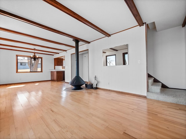6451 Stardust Ln NE, Carlos Twp, MN 56308 - unfurnished living room with healthy amount of natural light, beamed ceiling, wood finished floors, and stairs