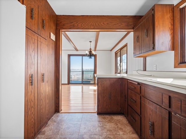 6451 Stardust Ln NE, Carlos Twp, MN 56308 - kitchen with a chandelier, light countertops, a peninsula, brown cabinets, and light tile patterned floors