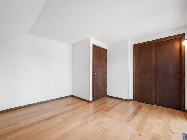 6451 Stardust Ln NE, Carlos Twp, MN 56308 - unfurnished bedroom with light wood-type flooring, vaulted ceiling, and baseboards