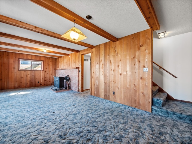 6451 Stardust Ln NE, Carlos Twp, MN 56308 - unfurnished living room with beam ceiling, carpet, wooden walls, a wood stove, and stairway
