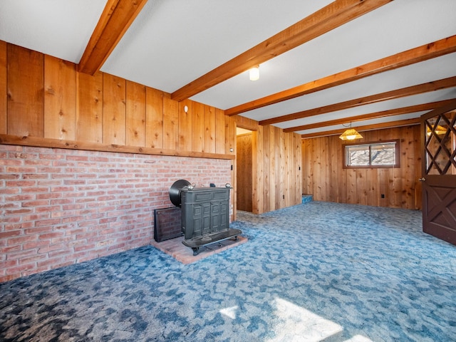 6451 Stardust Ln NE, Carlos Twp, MN 56308 - unfurnished living room with a wood stove, beam ceiling, carpet, wooden walls, and brick wall