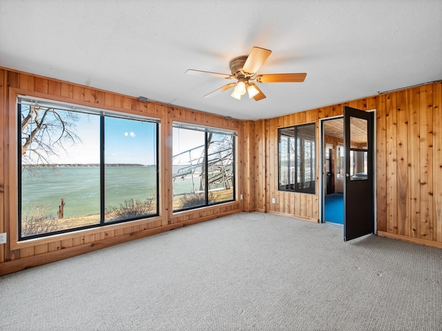 6451 Stardust Ln NE, Carlos Twp, MN 56308 - carpeted empty room featuring wooden walls, a ceiling fan, baseboards, and a water view