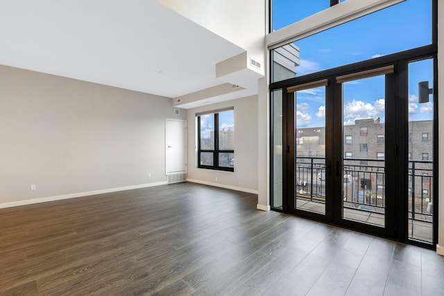 unfurnished room featuring a high ceiling and dark wood-type flooring