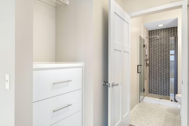 interior space featuring tile patterned floors, toilet, and a shower with door