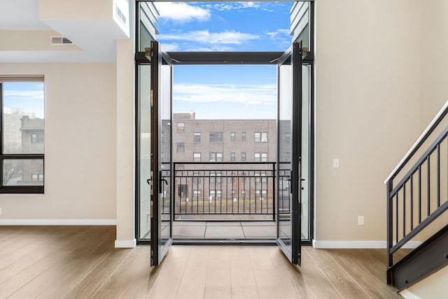 entryway featuring a wall of windows, plenty of natural light, and light wood-type flooring