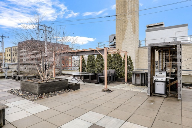 view of patio with area for grilling and a pergola