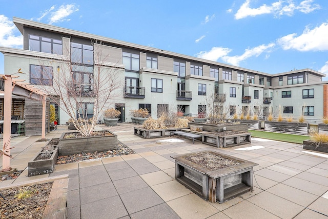 view of community with a fire pit and a patio