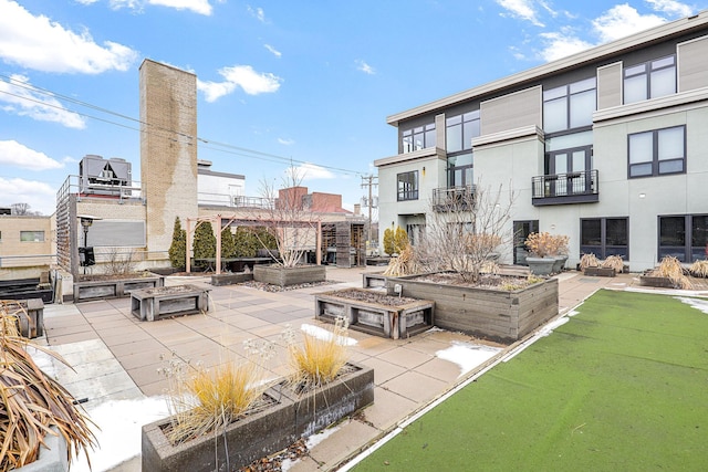 view of community with a patio and an outdoor fire pit