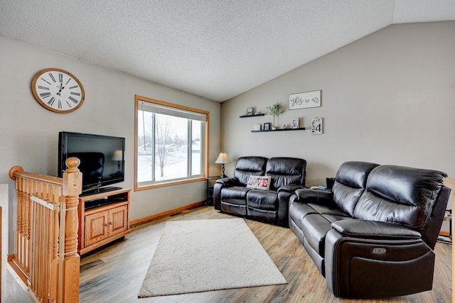 living area with vaulted ceiling, wood finished floors, and a textured ceiling