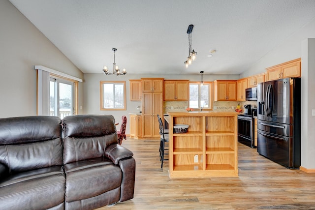 kitchen with stainless steel appliances, hanging light fixtures, and lofted ceiling