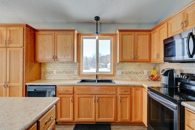 kitchen with pendant lighting, sink, stainless steel electric range, black dishwasher, and tasteful backsplash