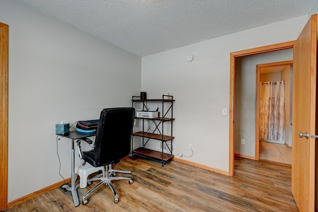 office featuring wood finished floors, baseboards, and a textured ceiling