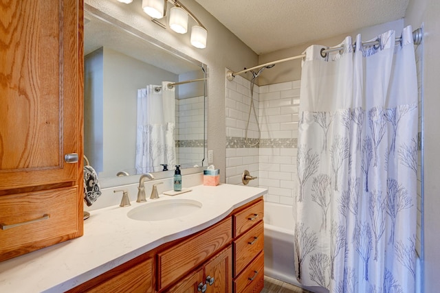 full bath featuring shower / bath combination with curtain, a textured ceiling, and vanity