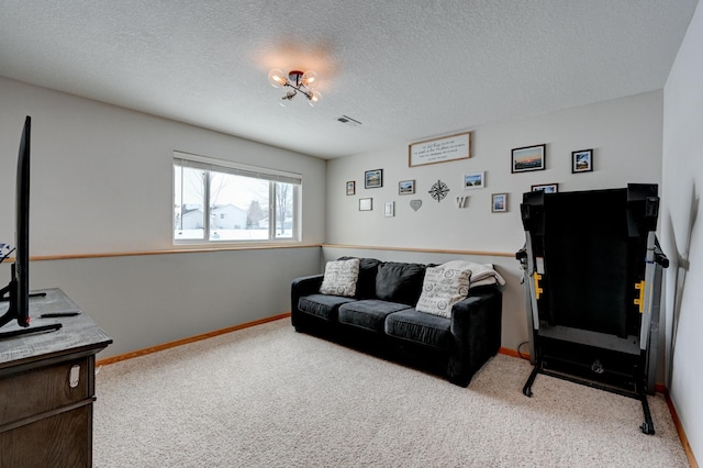 living area with visible vents, baseboards, carpet, and a textured ceiling