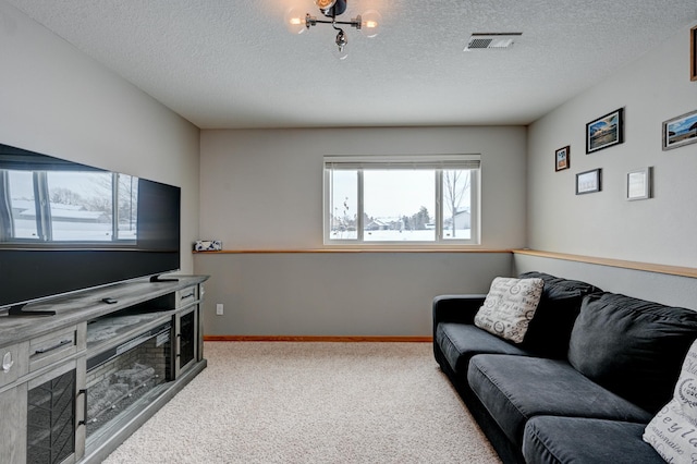 living area featuring baseboards, visible vents, carpet floors, and a textured ceiling