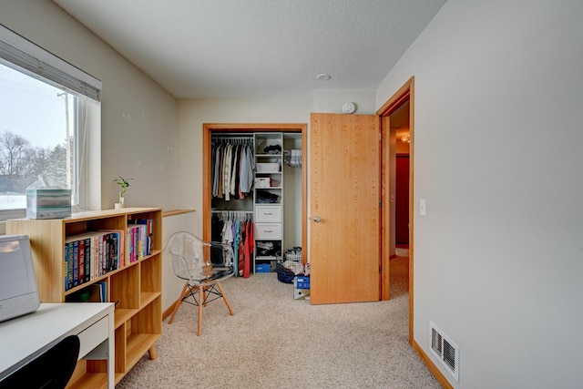 interior space featuring visible vents, a textured ceiling, and carpet flooring