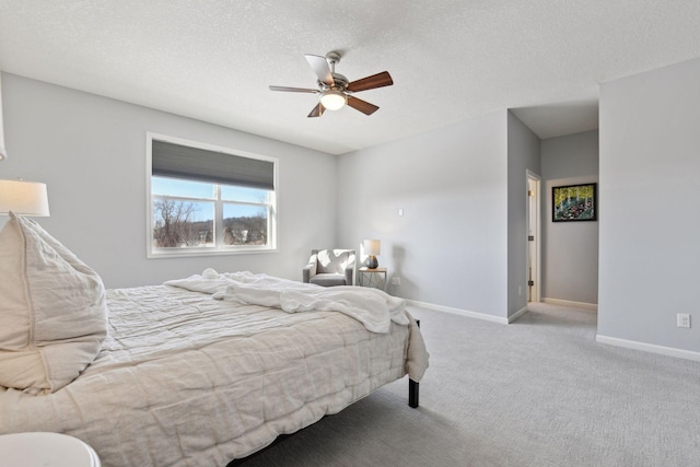 bedroom featuring a ceiling fan, baseboards, a textured ceiling, and light colored carpet