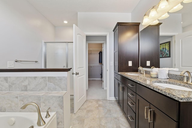 bathroom with a garden tub, a sink, a shower stall, and double vanity