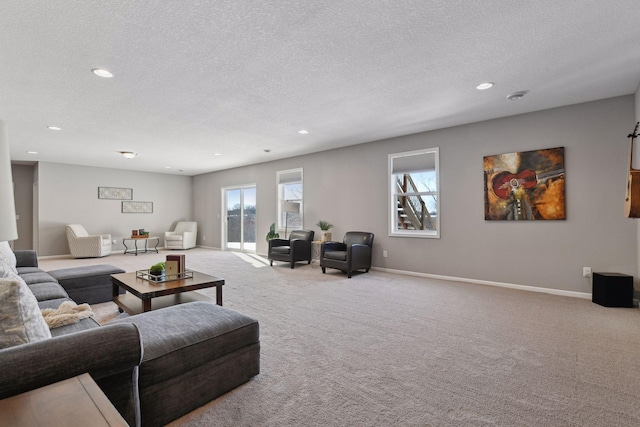 carpeted living area featuring a textured ceiling, recessed lighting, and baseboards